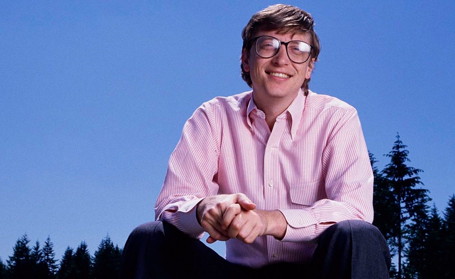 Bill Gates Sitting in very happy mode at the background beautiful sky